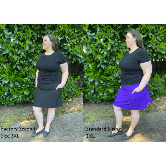 Woman wearing a black top and skirt with text indicating factory seconds and standard sizing.