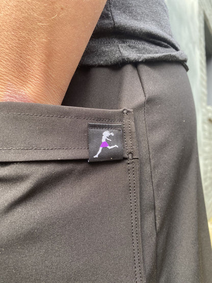 Close-up of a gray pants pocket with a brand logo on a blurred background