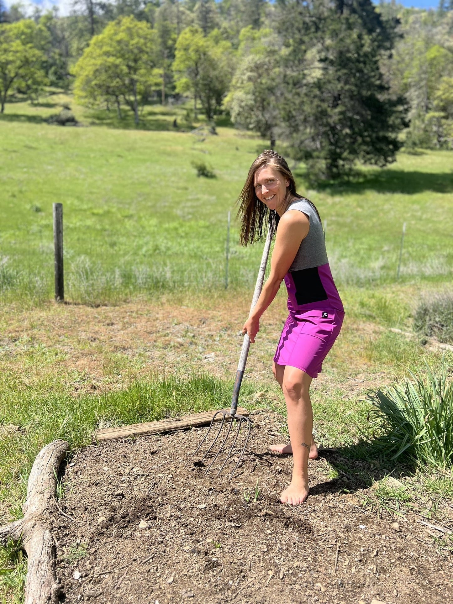 Person gardening in a field with a rake