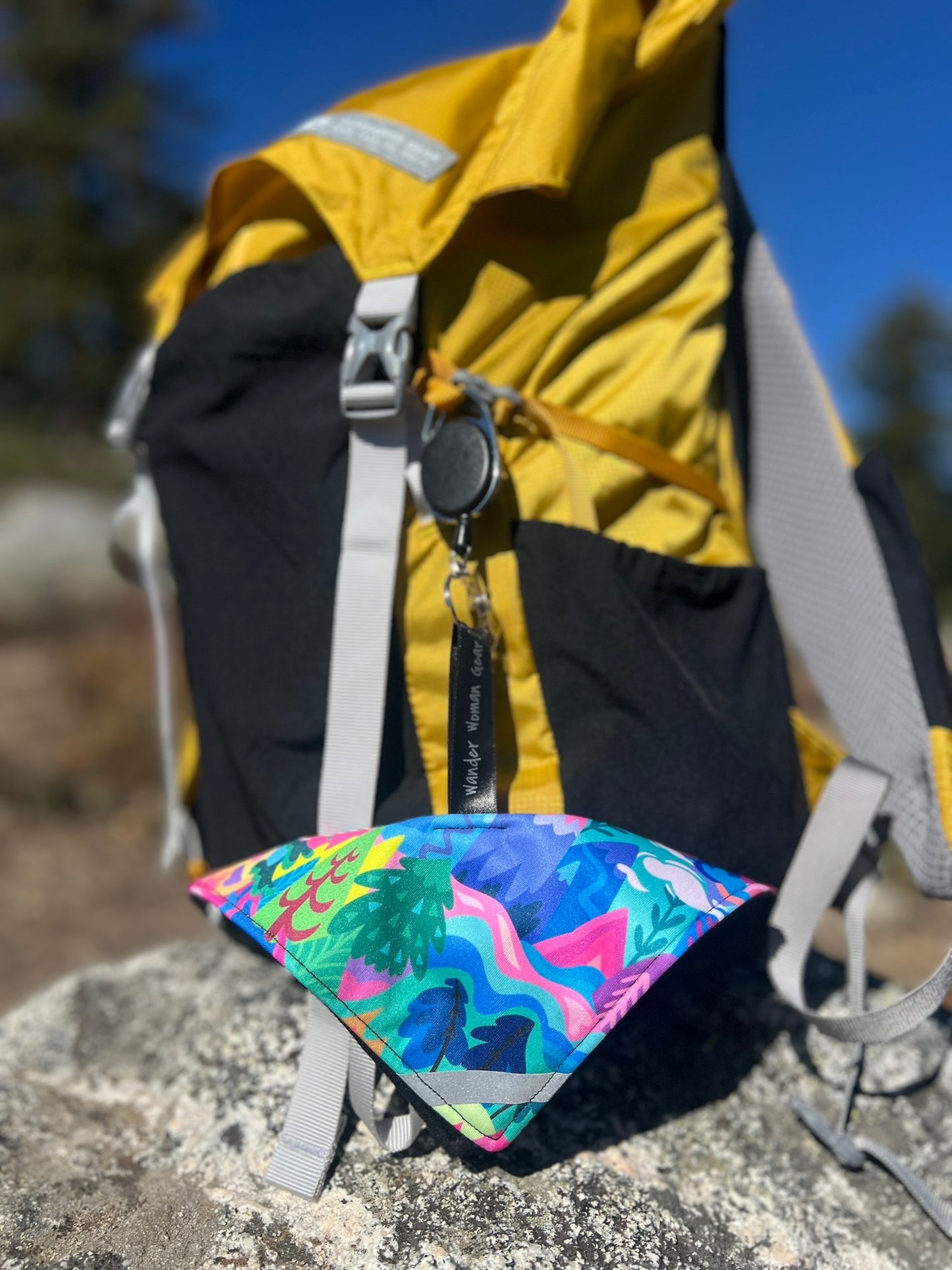 Colorful pee cloth attached to a backpack outdoors